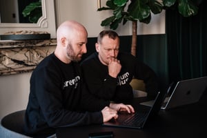 Two Premium Plus consultants reviewing Zendesk work together on a laptop